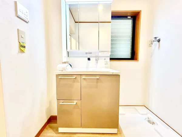 【洗面化粧台・洗濯機置き場】洗面化粧台横に洗濯機置場が設けられております。三面鏡裏、ボウル下に収納スペースを確保。洗剤等のストックや洗面小物が収納でき、スッキリと片付きます。※写真中の家具・家電・調…