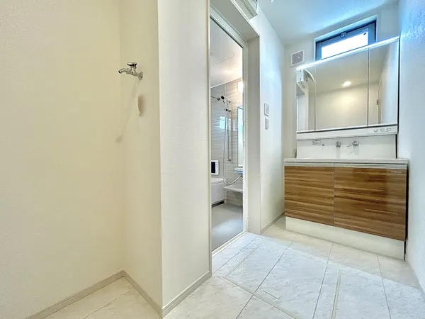 【洗面室】洗面室と浴室は段差がなく、どの世代の方にも使いやすい仕様です。床下に収納庫が備わっており、場所を取らずに洗剤のストック品などの収納にお使いいただけます。