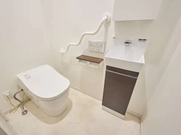 清潔感のある白を基調としたトイレです。温水洗浄便座付き、収納が設けられており、トイレットペーパーのストックや掃除用品などが収納できます。