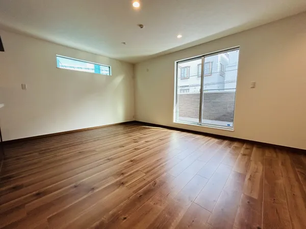 南向きの大きな窓と高窓から光が差し込む、広々としたリビングです。