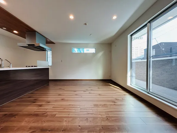 南向きの大きな窓とキッチンが並ぶLDK。明るい床材が広さを感じさせます。