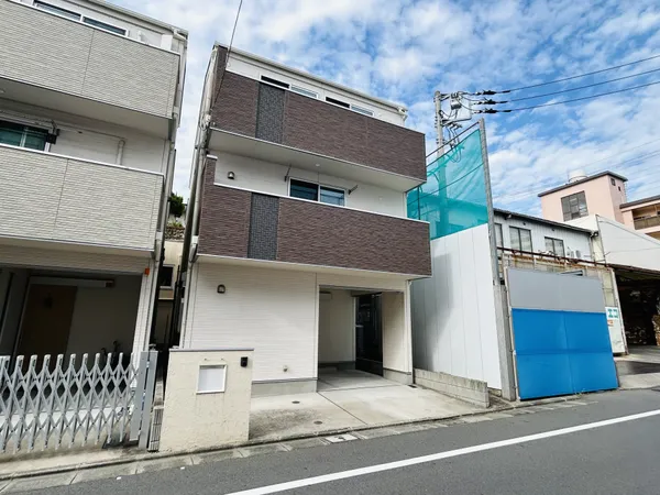 3階建ての戸建て外観。駐車スペース付きで、バルコニーが2面あります。