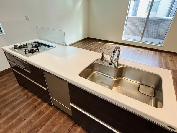 窓から自然光が入る対面式キッチン。広々とした作業スペースが特徴です。