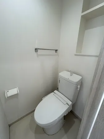 【2階トイレ】ホワイトを基調としたシンプルな内装です。上部には棚が設置されており、トイレットペーパーなどをまとめて収納可能です。