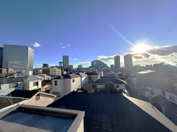 ルーフバルコニーからは、住宅街越しに広がる青空と高層ビル群を望む眺望が楽しめます。陽当たりが良く、開放感のある景色が魅力です。