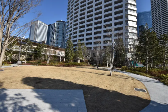 敷地内に広がる芝生のある共用ガーデン。周囲の植栽や遊歩道が開放感を演出しています。