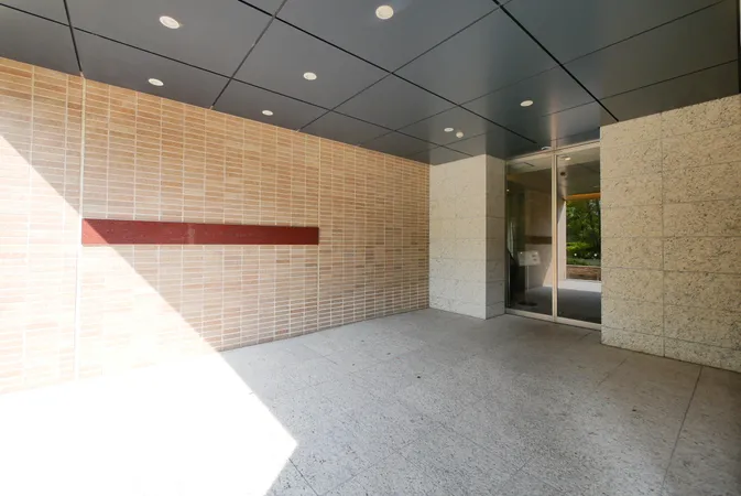 屋根付きのエントランス。タイル張りの壁とガラス扉が明るく開放的な印象です。