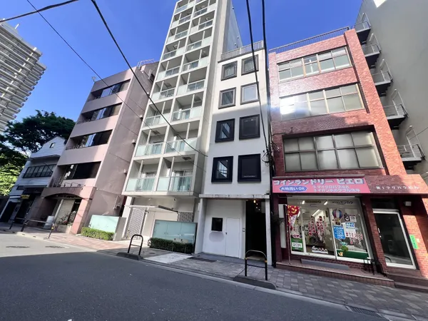 物件外観の写真です。通りに面したエントランスは明るく開放的な印象です。近隣にはコインランドリーなど生活利便施設もあり、日々の暮らしに便利な立地です。