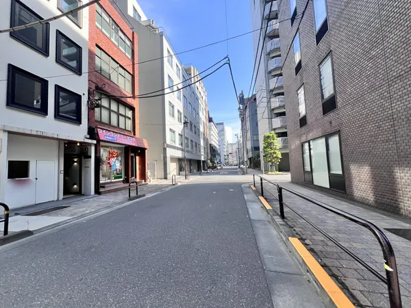 周辺はオフィスや店舗が並ぶ都市型の街並みで、道路幅も広く歩道が整備されています。日中は明るい雰囲気で、近隣には商店も見受けられ、生活利便性が高い印象です。