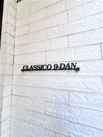 建物のエントランス付近に設置された「CLASSICO 9 DAN」の案内です。白い石調の外壁が明るく清潔感のある印象です。物件全体の雰囲気や外観のデザイン性を感じられるポイントです。