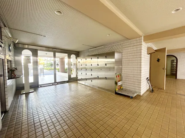 広々としたエントランス。明るいタイル床と大型メールボックスが設置されています。