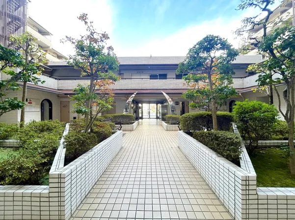 植栽が整えられた明るい共用エントランス。開放感のあるアプローチが印象的です。