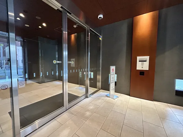 エントランスです。ガラス扉が設置され、外部からの視線を適度に遮りながらも、明るい光が差し込む空間となっています。オートロックやセキュリティカメラも設置されており、安心して暮らせる環境が整っています。