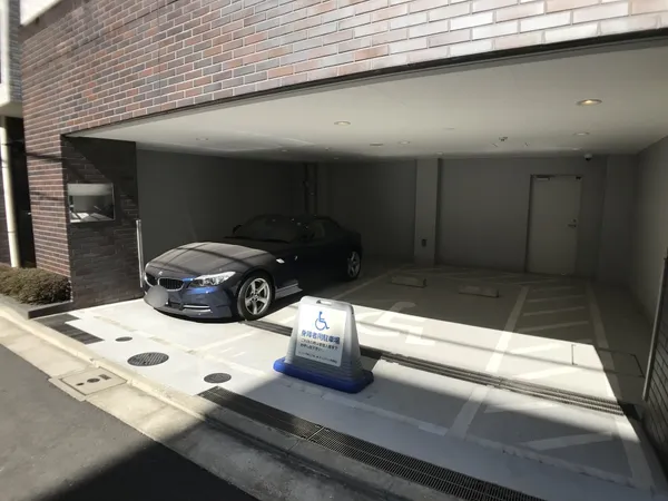 屋根付きの駐車場スペースです。車椅子利用者向けの区画が設けられており、雨天時も乗降がしやすい設計となっています。入口付近には段差がなく、車両の出入りもスムーズです。