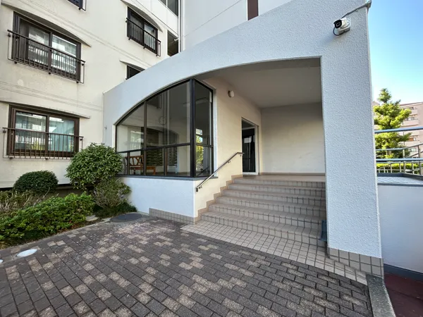 植栽に囲まれたエントランス。階段を上がると屋根付きの玄関スペースが広がります。