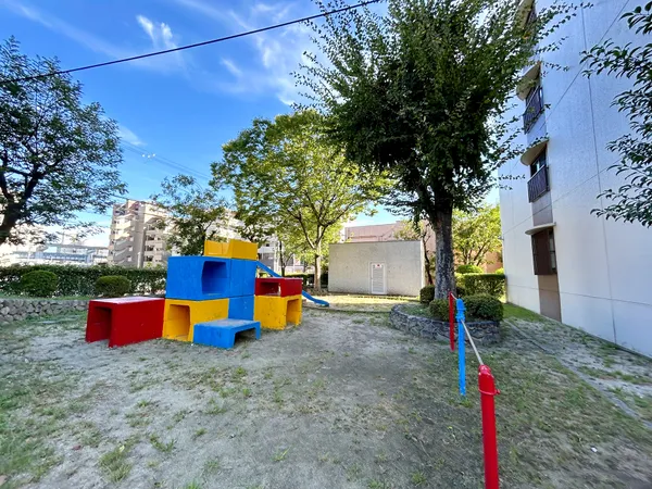 敷地内の遊具付き広場。木陰があり、外遊びや休憩に活用できるスペースです。