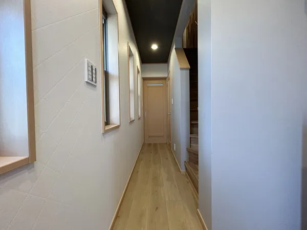 【廊下】玄関側から見た1階の廊下です。正面の扉が洗面室の出入口です。