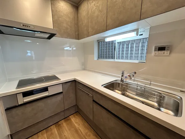 【キッチン】キッチン台はL字型の壁付タイプが採用されています。上下に収納スペースが設けられており、すっきりとした空間を保つのに役立ちます。