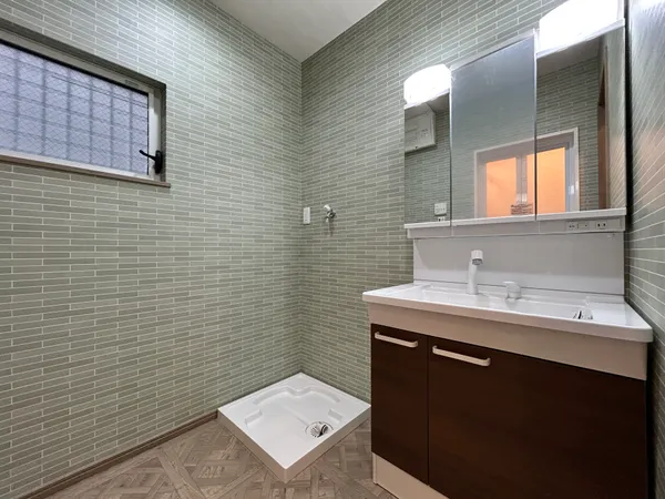 【洗面室】洗面室内には三面鏡の洗面化粧台や洗濯パンが設置してあります。玄関から近い位置にあり、衛生面にも配慮された間取りとなっています。