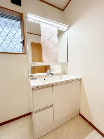 三面鏡付きです。洗面化粧台横にリネン庫が備わっており、ストック品やタオルなどの収納にお使いいただけます。