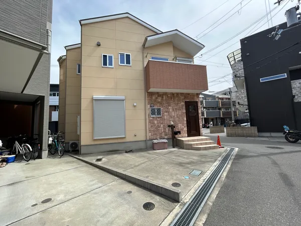 広い前面スペースは駐車や自転車置き場として活用でき、道路からのアクセスもスムーズです。玄関周りは段差が少なく、荷物の搬入や来客時にも便利な構造です。周囲は住宅街で、落ち着いた雰囲気が感じられます。