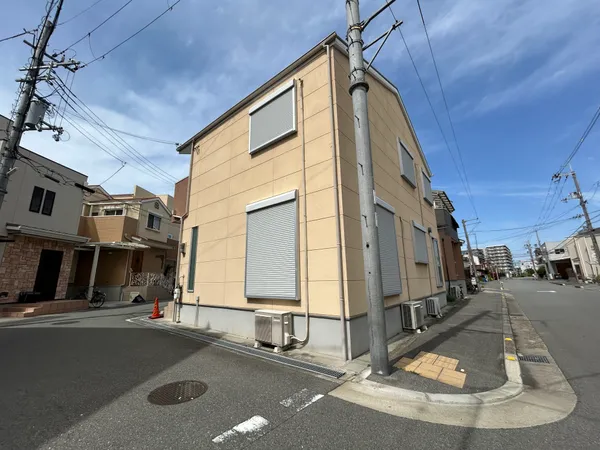 道路幅が広く、車の出入りや歩行者の視界が良い印象です。シャッター付きの窓が複数あり、防犯や遮光にも配慮された造りです。周辺は住宅街で、落ち着いた環境が想像できます。