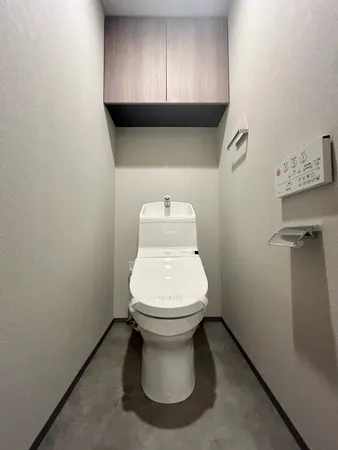 お掃除のしやすいシンプルな内装です。トイレ上部に吊戸棚が設けられており、トイレットペーパーのストックや掃除道具を収納いただけます。