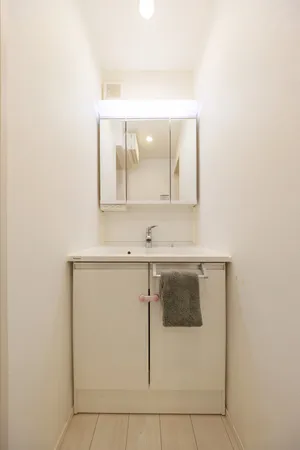 【洗面室】身支度がしやすく、収納力のある三面鏡付き洗面化粧台が備わっています。ボウルとカウンターは、継ぎ目のない一体型です。