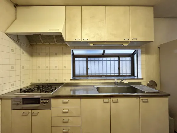 コンロは効率良く調理ができるグリル付きの三口ガスコンロ。上部吊り戸棚とシンク下・コンロ下に収納スペースがございます。