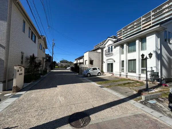前面道路と住宅街の様子です。幅のある道路で車の出入りもスムーズに行えます。青空が広がり、周辺は落ち着いた住環境です。