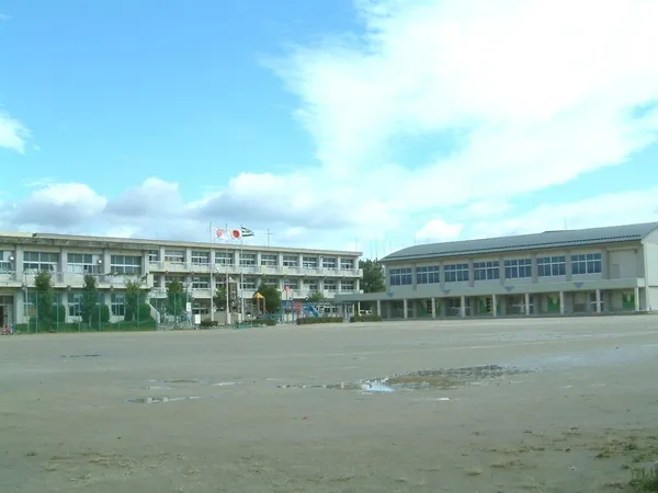 岡崎市立六名小学校（約450ｍ）の外観写真です。広い校庭と校舎が見え、周辺環境の参考になります。