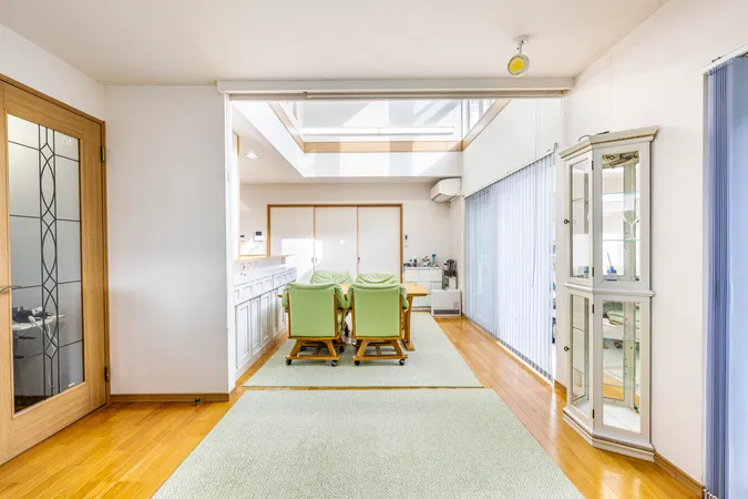 リビングは、吹抜けから光が差し込む明るい空間で、広々としたLDKが魅力。大きな窓とサンルームに面し、開放感と快適さを兼ね備えています。