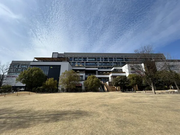 広々とした芝生広場と商業施設が一体となった外観です。開放的な空間で日常の利便性が感じられます。