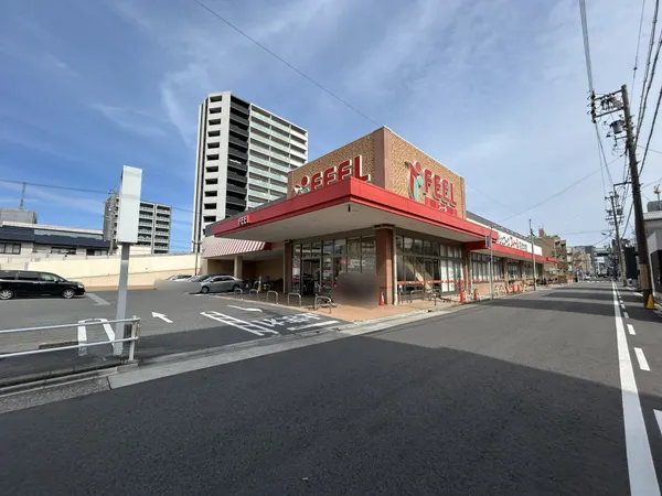 フィール花の木店の外観。駐車場が広く、周辺はマンションや住宅が立ち並ぶ環境です。