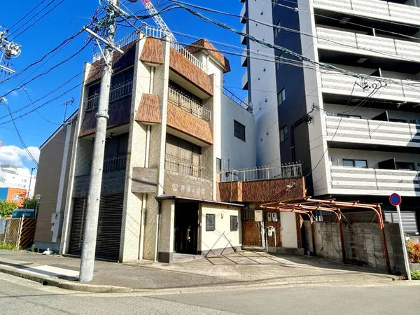 3階建ての建物外観。南西向きで日当たりが良く、駐車スペースも確保されています。