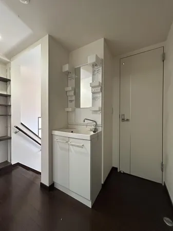 【2階洗面台】シンプルで清潔感のある洗面台。収納棚付きで使いやすく、階段近くの便利な配置が日常を快適にします。