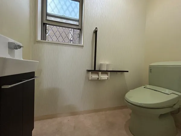 【1階】窓付きで明るいトイレ。手洗いカウンターと棚を備え、使いやすさと清潔感を兼ね備えた快適な空間です。