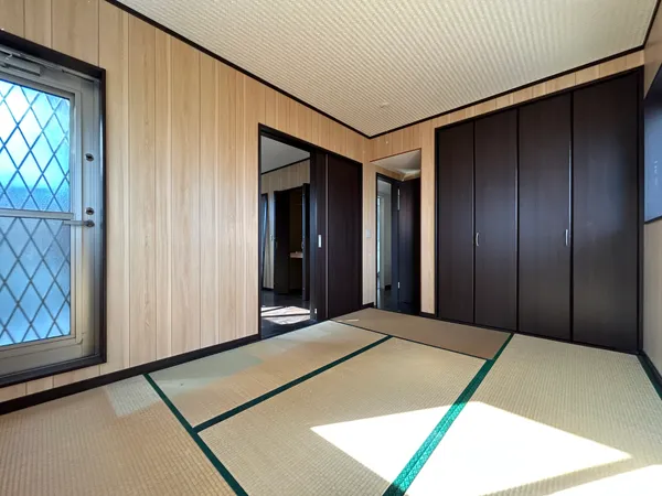 【2階和室】木目調の壁と畳が調和する落ち着きの和室。大容量収納を備え、明るい窓から光が差し込み、バルコニーへも出られます。