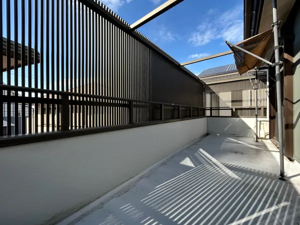 【バルコニー】縦格子の目隠しでプライバシーを確保した広々バルコニー。陽当たり良好で洗濯やくつろぎスペースに適しています。