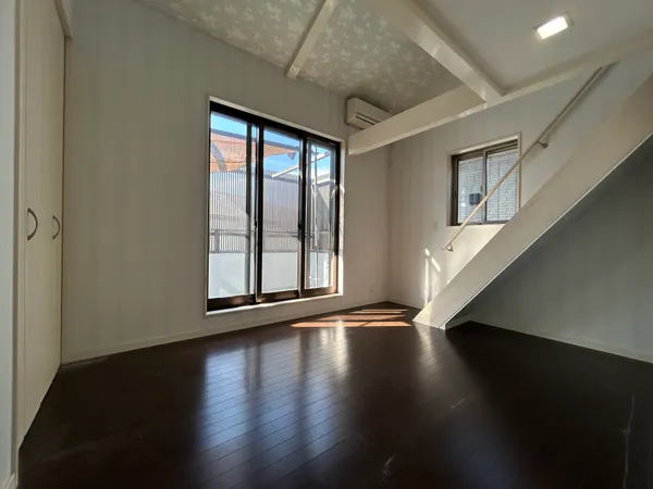 【洋室 約6.0帖】大きな窓から光が差し込む明るい空間。階段下を活用したすっきり設計で、開放感と機能性を兼ね備えています。