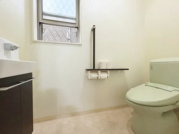 【1階】窓付きで明るいトイレ。手洗いカウンターと棚を備え、使いやすさと清潔感を兼ね備えた快適な空間です。