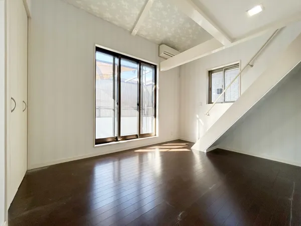 【洋室 約6.0帖】大きな窓から光が差し込む明るい空間。階段下を活用したすっきり設計で、開放感と機能性を兼ね備えています。