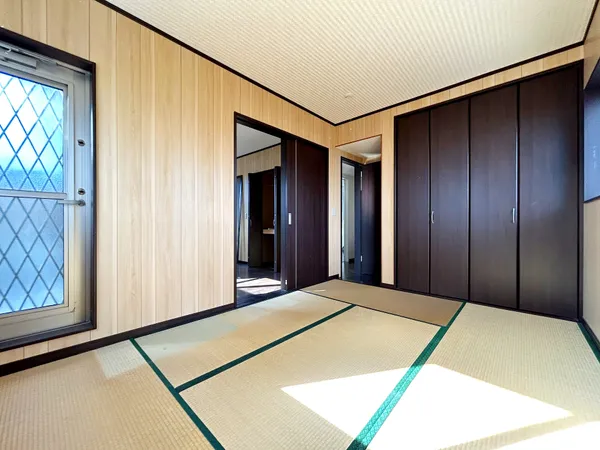 【2階和室】木目調の壁と畳が調和する落ち着きの和室。大容量収納を備え、明るい窓から光が差し込み、バルコニーへも出られます。