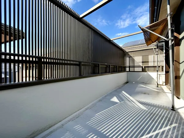 【バルコニー】縦格子の目隠しでプライバシーを確保した広々バルコニー。陽当たり良好で洗濯やくつろぎスペースに適しています。