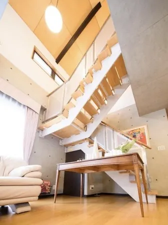 大きな吹き抜けから優しい光が降り注ぐリビング。天井高と窓の配置により、時間帯によって表情が変わる心地よい空間です。