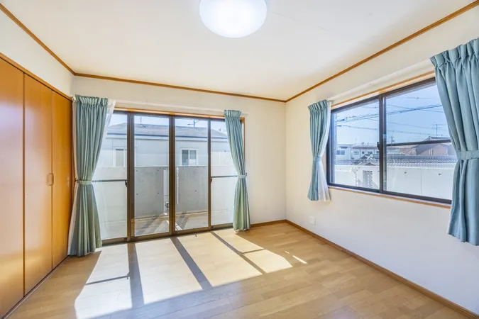 窓から光が差し込む南西向き洋室。収納も備えた明るい空間です。